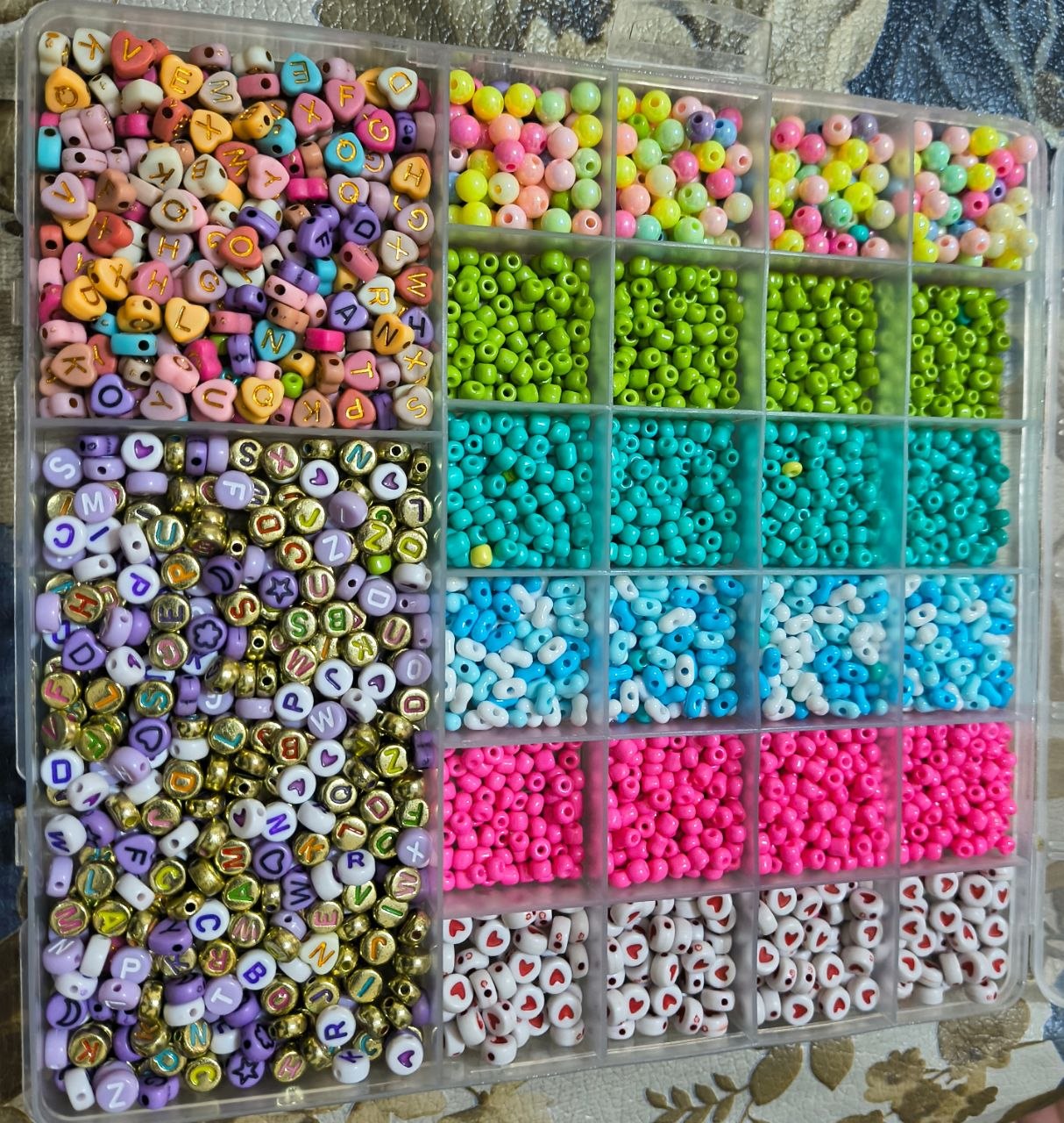 Caja con cuentas de colores, letras, corazones y mostacillas para personalizar pulseras
